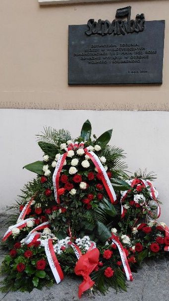 Pamięci wydarzeń z 1982 w Toruniu. Kwiaty po tablicą na kościele jezuitów